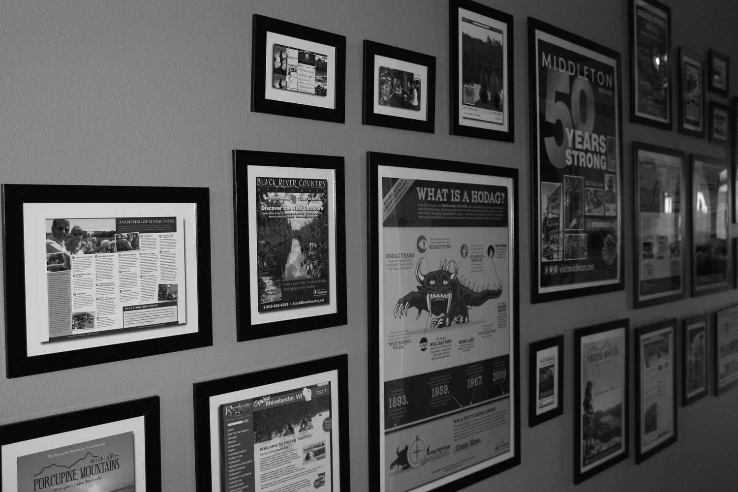 Wall with framed pictures of Pilch + Barnet's work