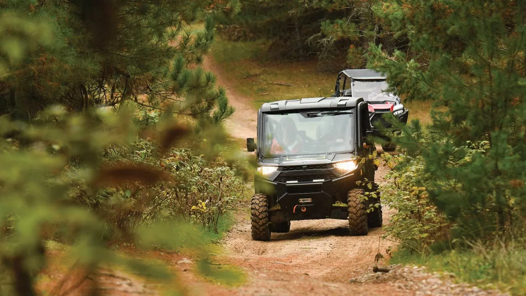 UTVers driving on a gravel trail in fall